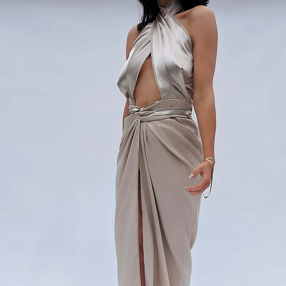 
                      
                        Woman wearing a beautiful halter neck champagne satin dress with a wrap waist
                      
                    