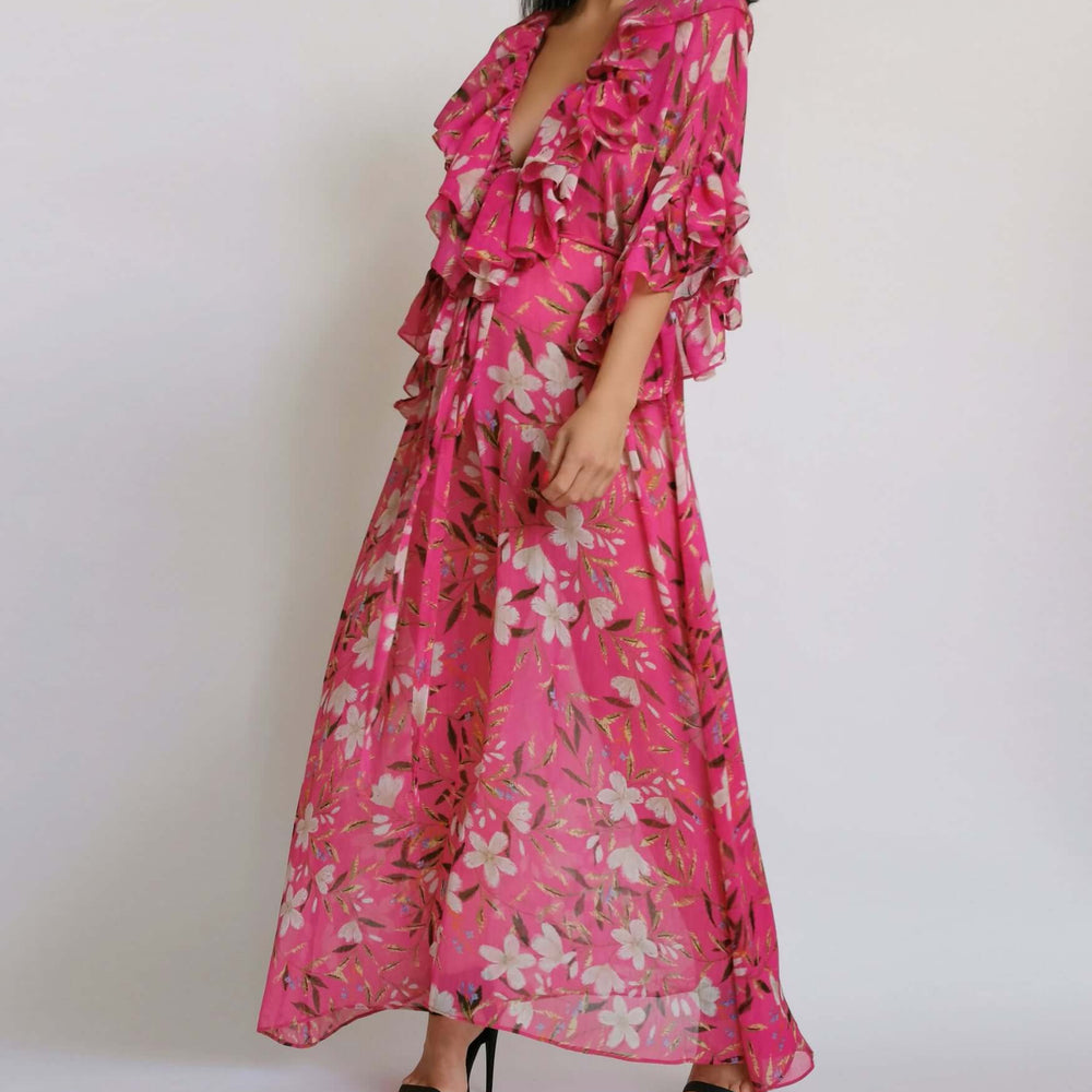 
                      
                        Model elegantly dressed in a pink floral print outfit.
                      
                    